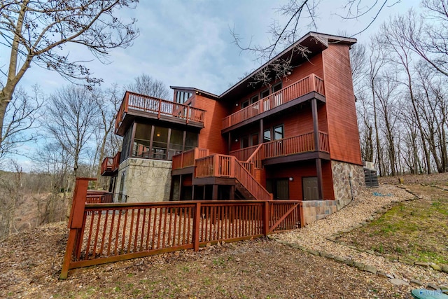 back of property with stairway, central AC, and a balcony