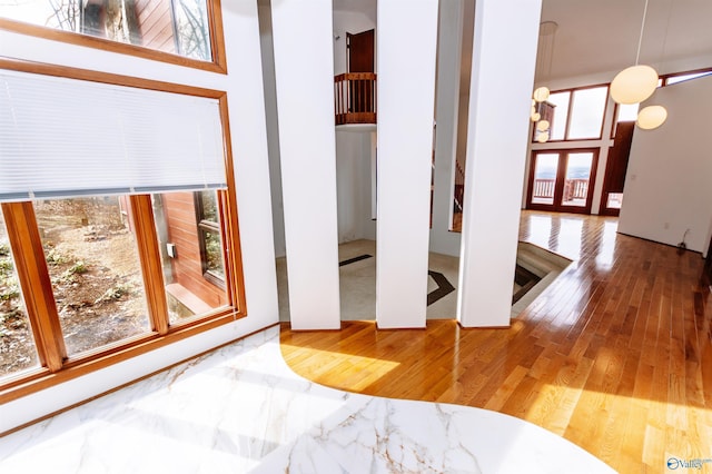 interior space with plenty of natural light, hardwood / wood-style floors, and a high ceiling