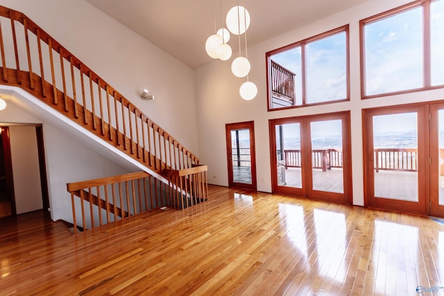 foyer entrance with hardwood / wood-style flooring, stairs, and a high ceiling