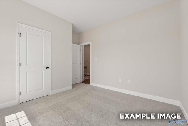 unfurnished bedroom with carpet flooring and baseboards