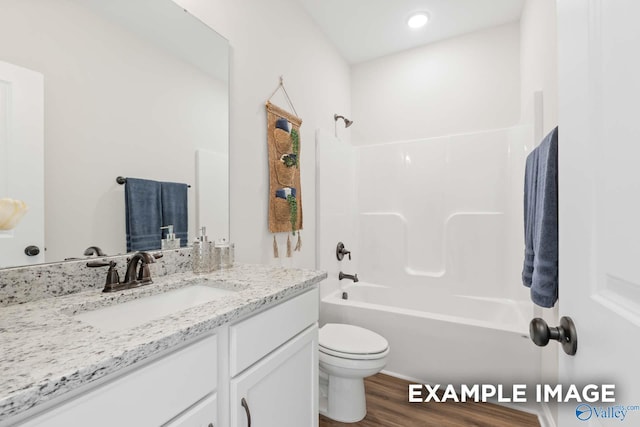full bath with shower / bath combination, wood finished floors, toilet, and vanity