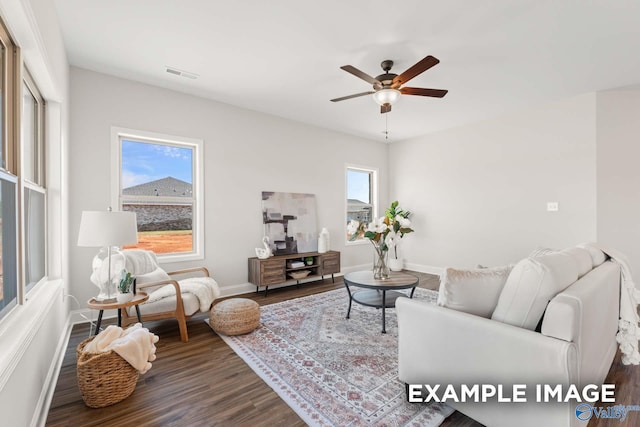 living area featuring ceiling fan, baseboards, wood finished floors, and visible vents
