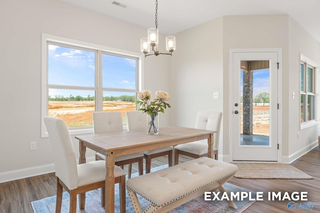 dining space with wood finished floors, visible vents, baseboards, and an inviting chandelier