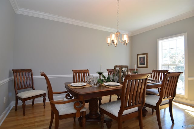 dining room with a notable chandelier, wood-type flooring, and crown molding