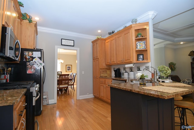 kitchen with kitchen peninsula, a kitchen breakfast bar, ornamental molding, stainless steel appliances, and light hardwood / wood-style flooring