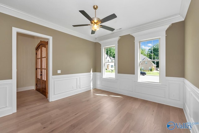 unfurnished room with ornamental molding, ceiling fan, and light wood-type flooring