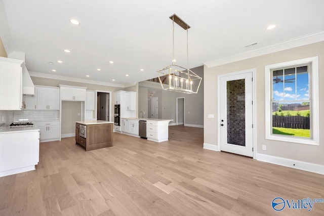 kitchen featuring white cabinetry, pendant lighting, a center island, and appliances with stainless steel finishes