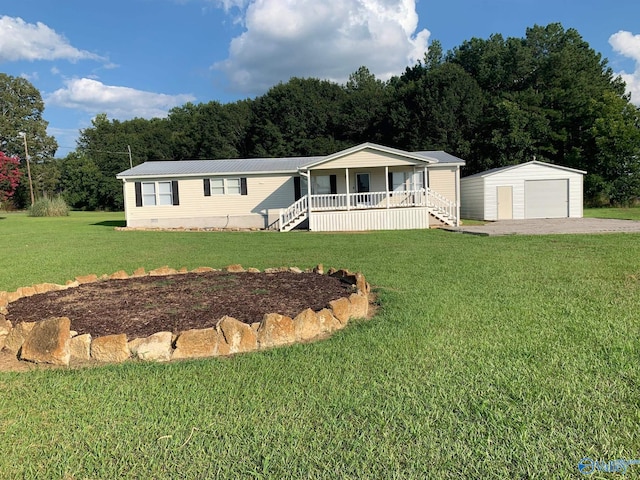 manufactured / mobile home featuring an outbuilding, a porch, a garage, and a front yard