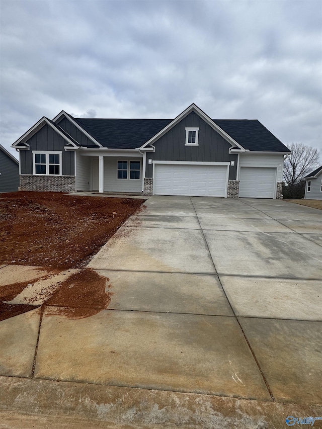 view of front of property with board and batten siding, driveway, roof with shingles, and an attached garage