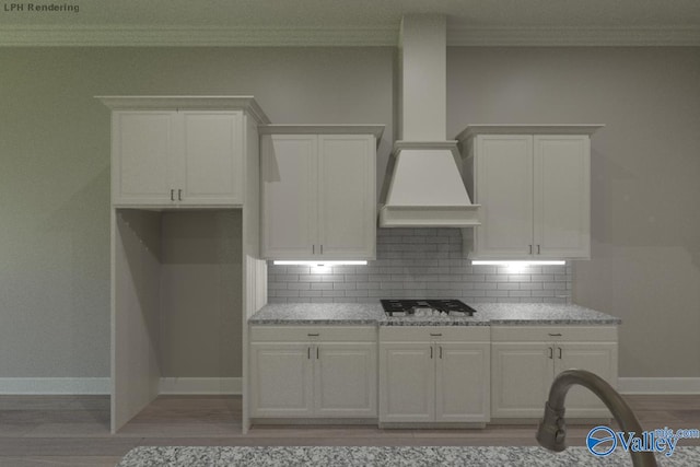 kitchen featuring gas stovetop, custom range hood, white cabinetry, and light stone counters