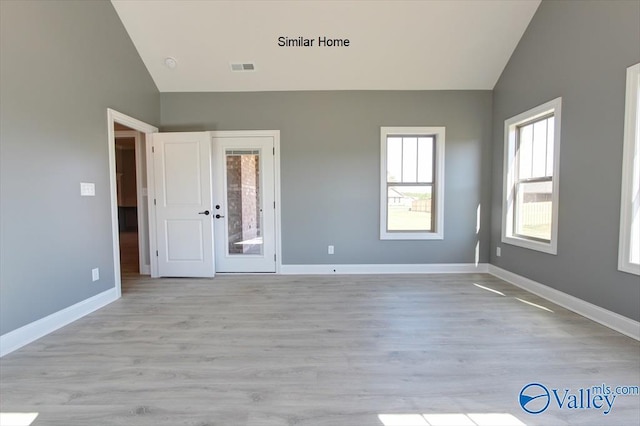 unfurnished bedroom featuring lofted ceiling, baseboards, visible vents, and light wood finished floors