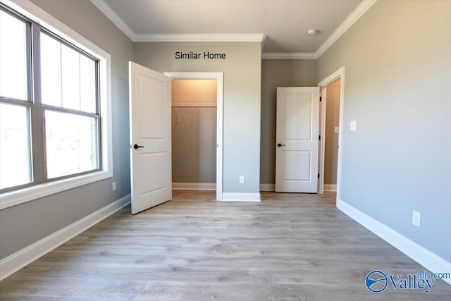 unfurnished bedroom featuring ornamental molding, a closet, light wood-style flooring, and baseboards