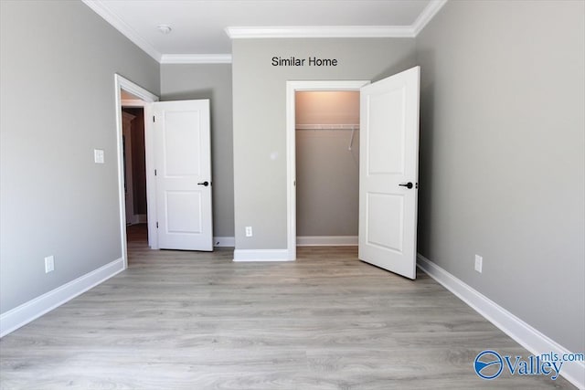 unfurnished bedroom with a closet, crown molding, light wood-style flooring, and baseboards