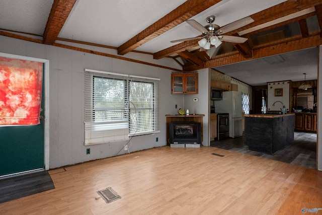 living room featuring lofted ceiling with beams, wood-type flooring, and ceiling fan