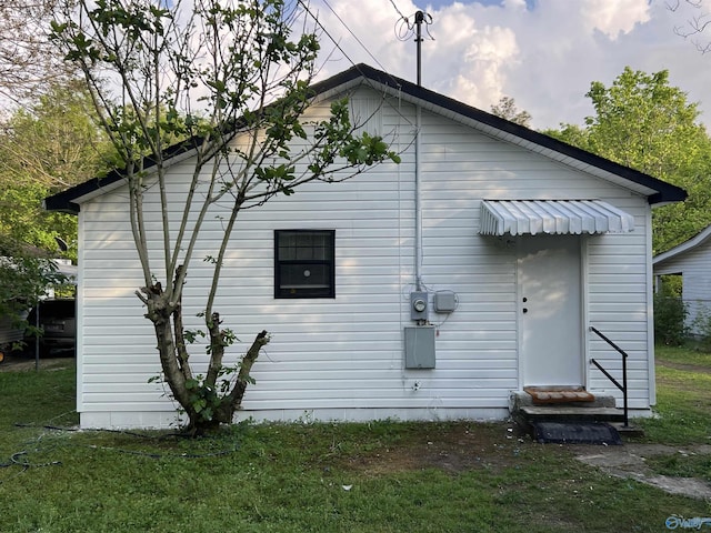 rear view of property featuring a yard