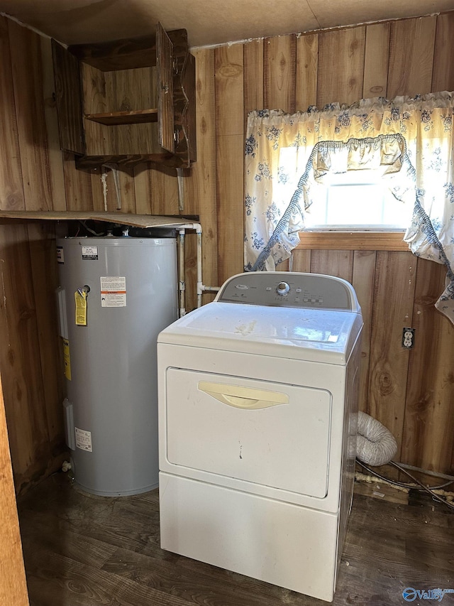 clothes washing area featuring washer / clothes dryer, water heater, and dark wood-type flooring