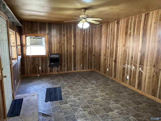 spare room with a wall unit AC, heating unit, wooden walls, and ceiling fan