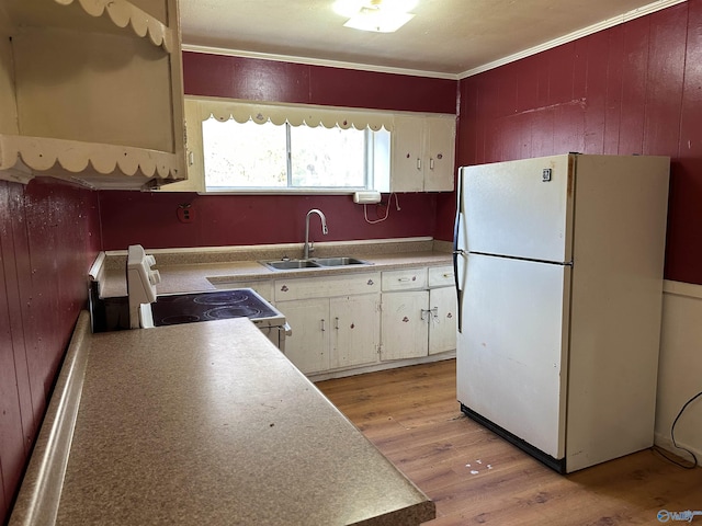 kitchen with white cabinets, white refrigerator, sink, light hardwood / wood-style flooring, and range