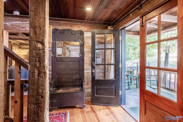 doorway to outside with light wood-type flooring and wooden ceiling