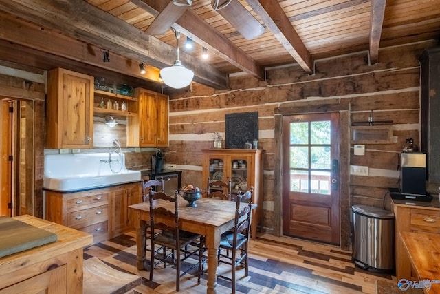 kitchen with wood-type flooring, wooden walls, decorative light fixtures, and wood ceiling