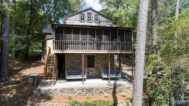 rear view of house featuring a patio and a sunroom