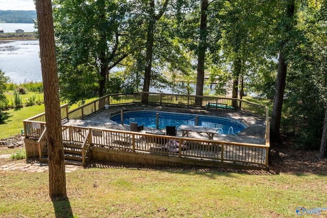 view of pool featuring a deck with water view and a yard