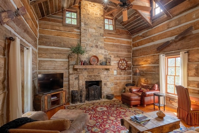 living room with ceiling fan, a fireplace, plenty of natural light, and wood-type flooring