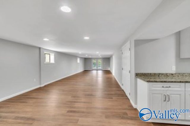 interior space featuring recessed lighting, baseboards, and light wood finished floors