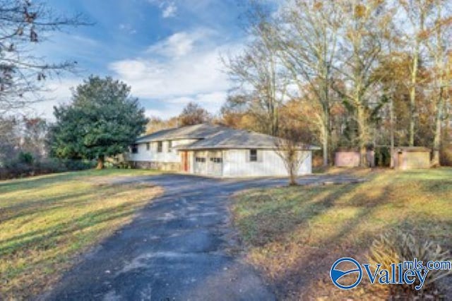 view of property exterior with a yard and driveway