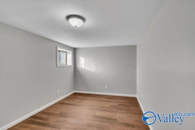 spare room featuring wood finished floors and baseboards