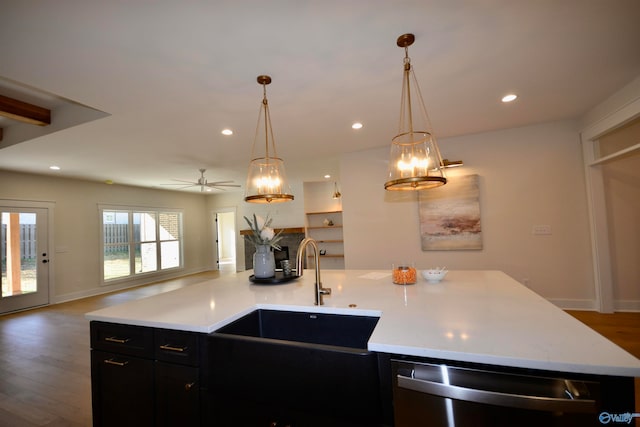 kitchen with sink, hanging light fixtures, stainless steel dishwasher, and wood-type flooring