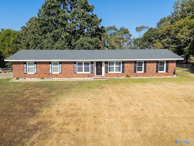 single story home with a shingled roof, a front lawn, and brick siding