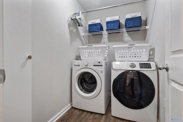 clothes washing area with dark hardwood / wood-style floors and separate washer and dryer