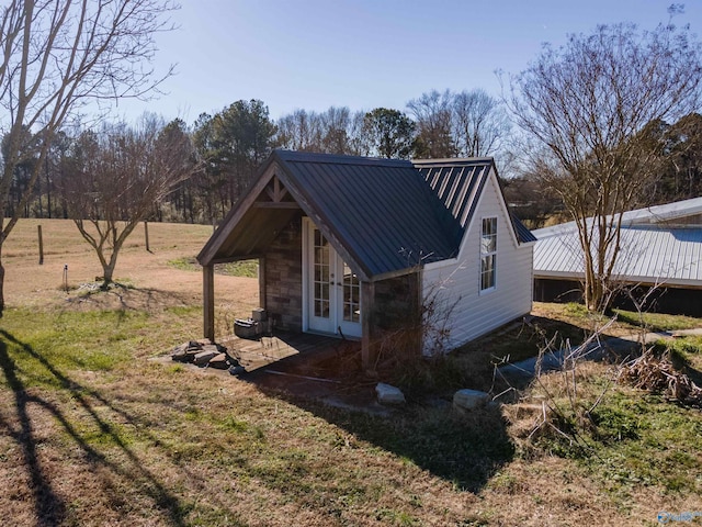 view of home's exterior with a lawn and french doors