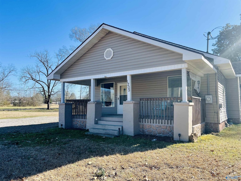 bungalow-style house with covered porch and a front yard