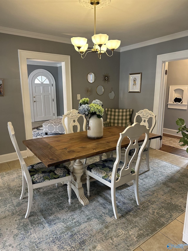 dining space featuring ornamental molding, light tile patterned flooring, baseboards, and an inviting chandelier