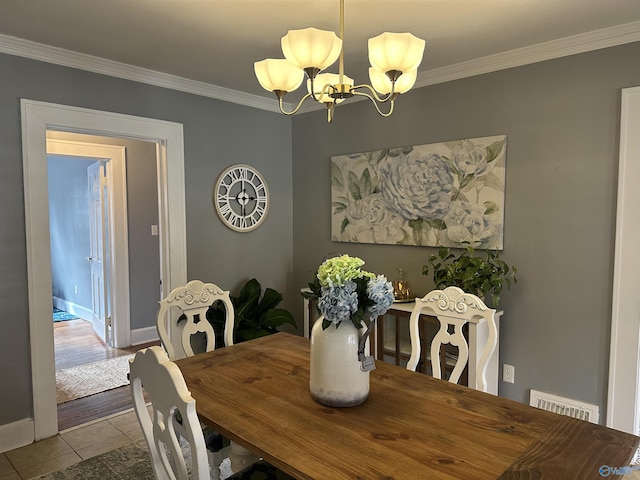 dining space featuring ornamental molding, tile patterned floors, visible vents, and an inviting chandelier