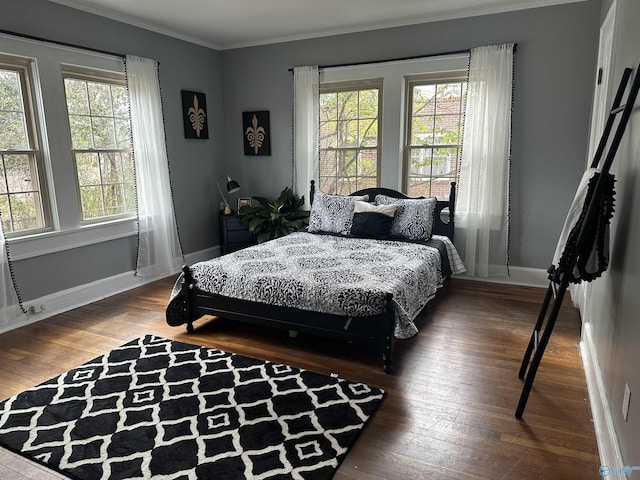 bedroom with multiple windows, ornamental molding, and dark wood-style flooring