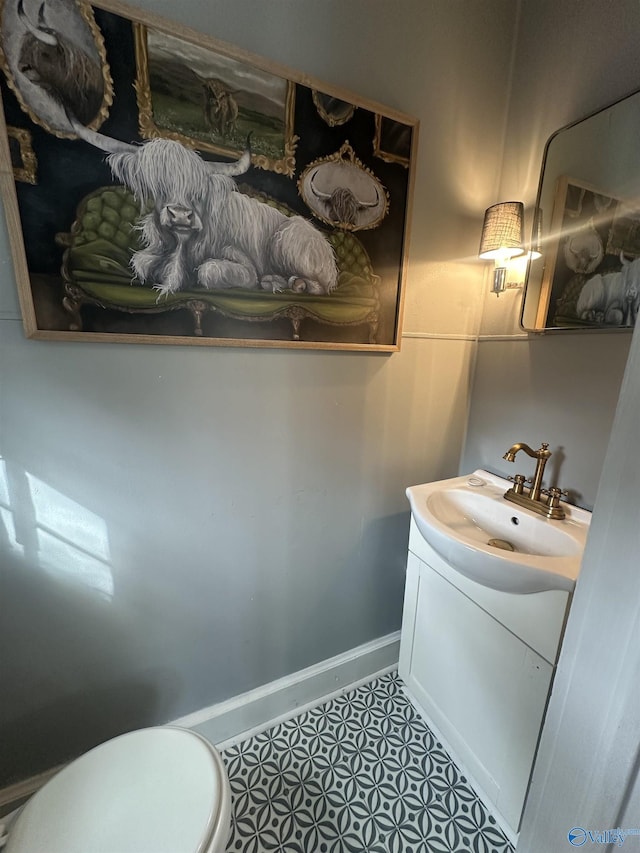 bathroom featuring tile patterned flooring, baseboards, vanity, and toilet