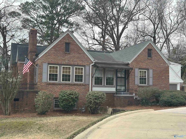 view of front of house with a chimney and brick siding