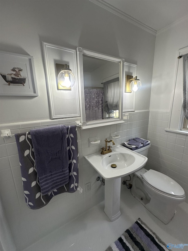 full bath featuring wainscoting, crown molding, tile walls, and toilet