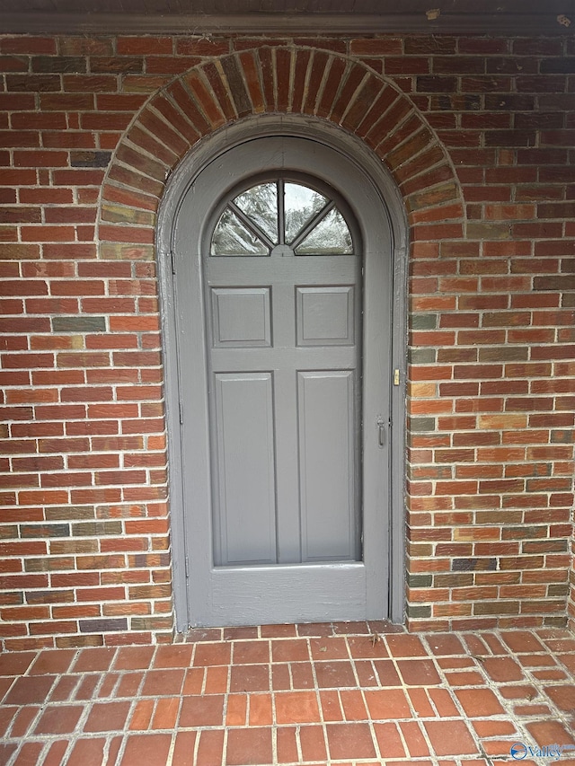 view of exterior entry with brick siding