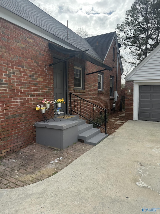 view of home's exterior featuring a shingled roof, brick siding, and a garage