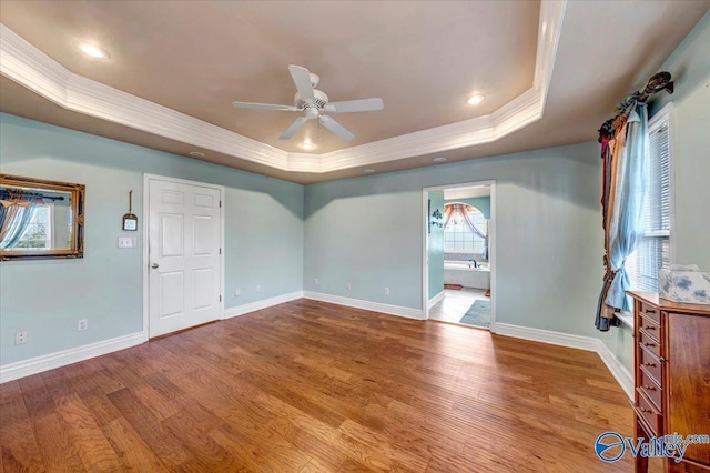 unfurnished room featuring ceiling fan, crown molding, wood-type flooring, and a tray ceiling