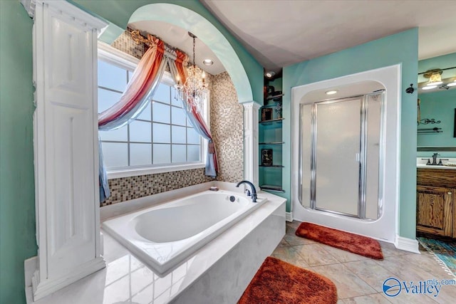 bathroom featuring tile patterned floors, vanity, an inviting chandelier, and plus walk in shower