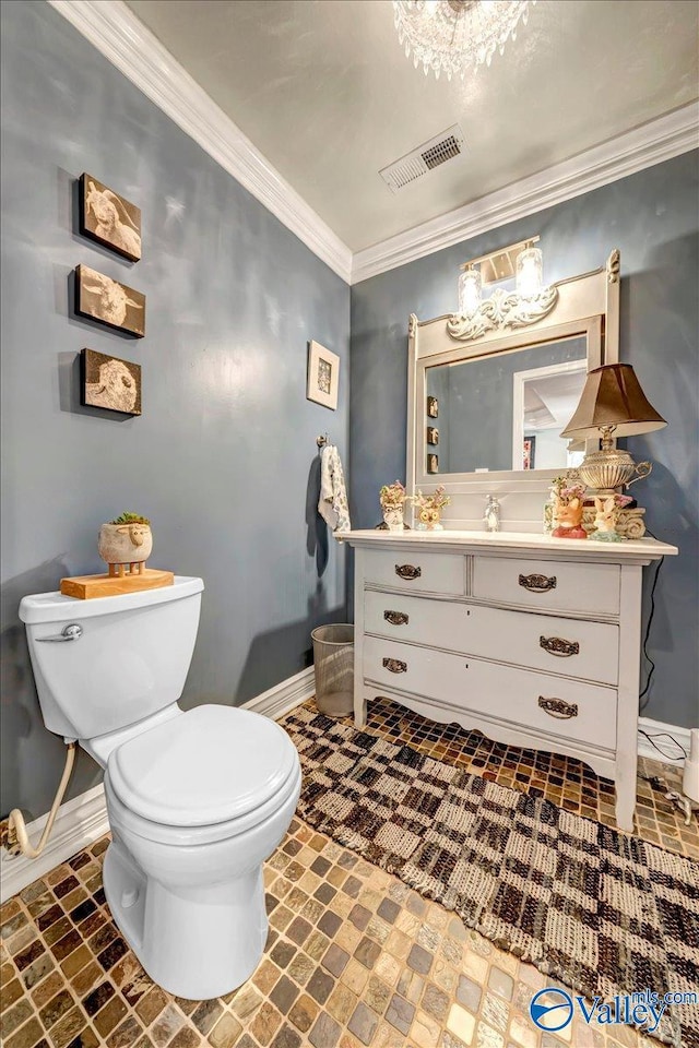 bathroom featuring toilet, vanity, and ornamental molding