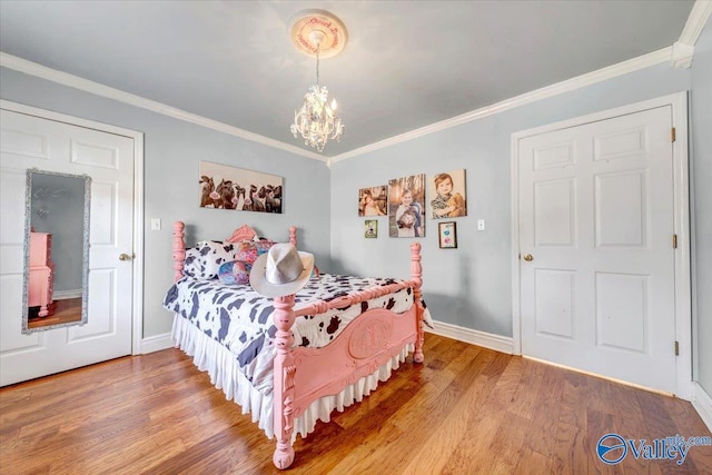 bedroom featuring hardwood / wood-style flooring, crown molding, and an inviting chandelier