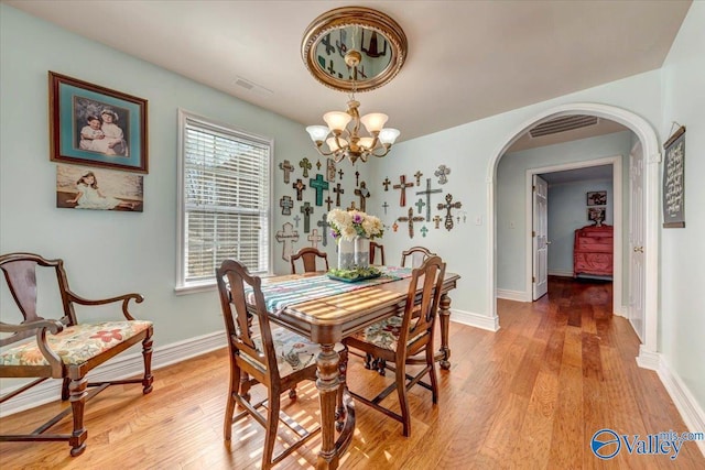 dining room with an inviting chandelier and light hardwood / wood-style flooring