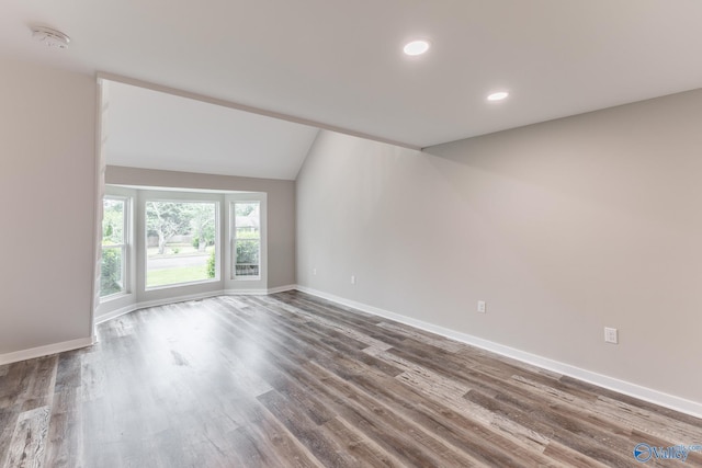 spare room with recessed lighting, baseboards, vaulted ceiling, and wood finished floors
