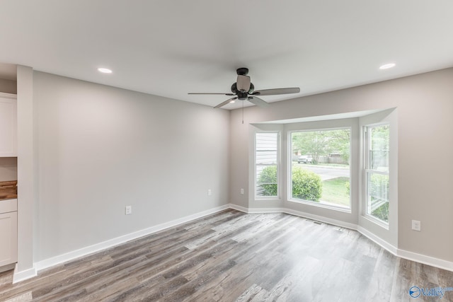 empty room featuring plenty of natural light, recessed lighting, ceiling fan, and wood finished floors
